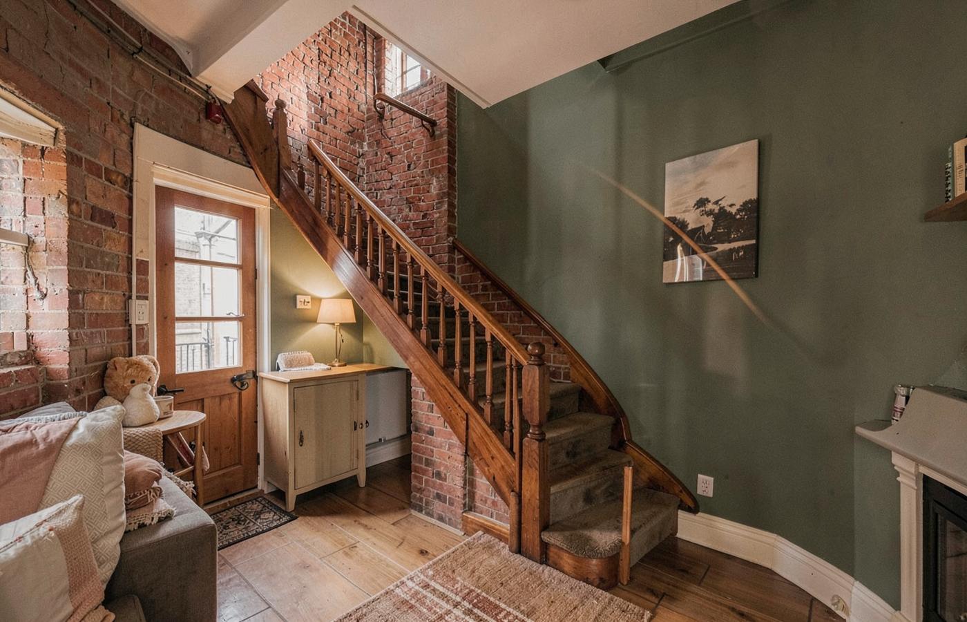Hallway with wooden staircase and green walls